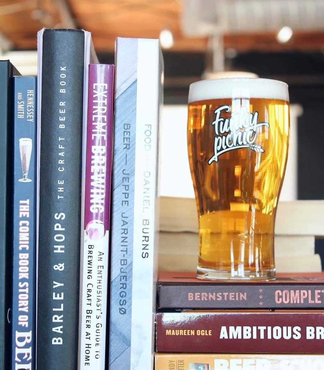 Funky Picnic beer sitting on a stack of books about beer.