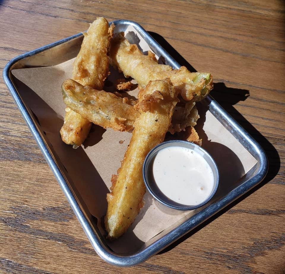 Silver tray with battered pickle spears and a ramekin of ranch
